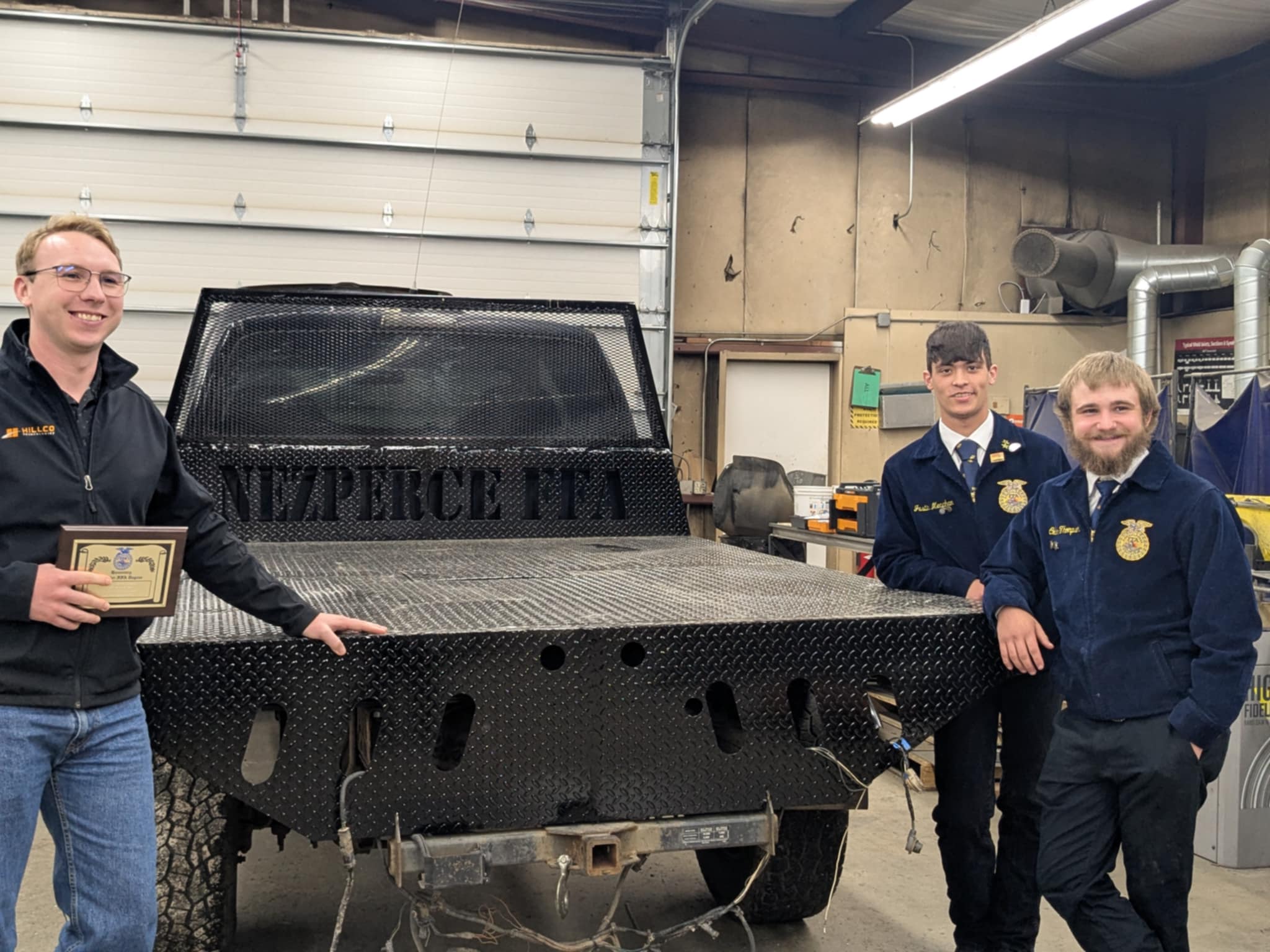 Sales Director Preston Hill with Nezperce FFA students and custom flatbed built with help from Hillco